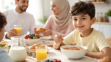 طفل يتناول حبوب الإفطار على مائدة الإفطار مع عائلته في صباح منزلي هادئ
